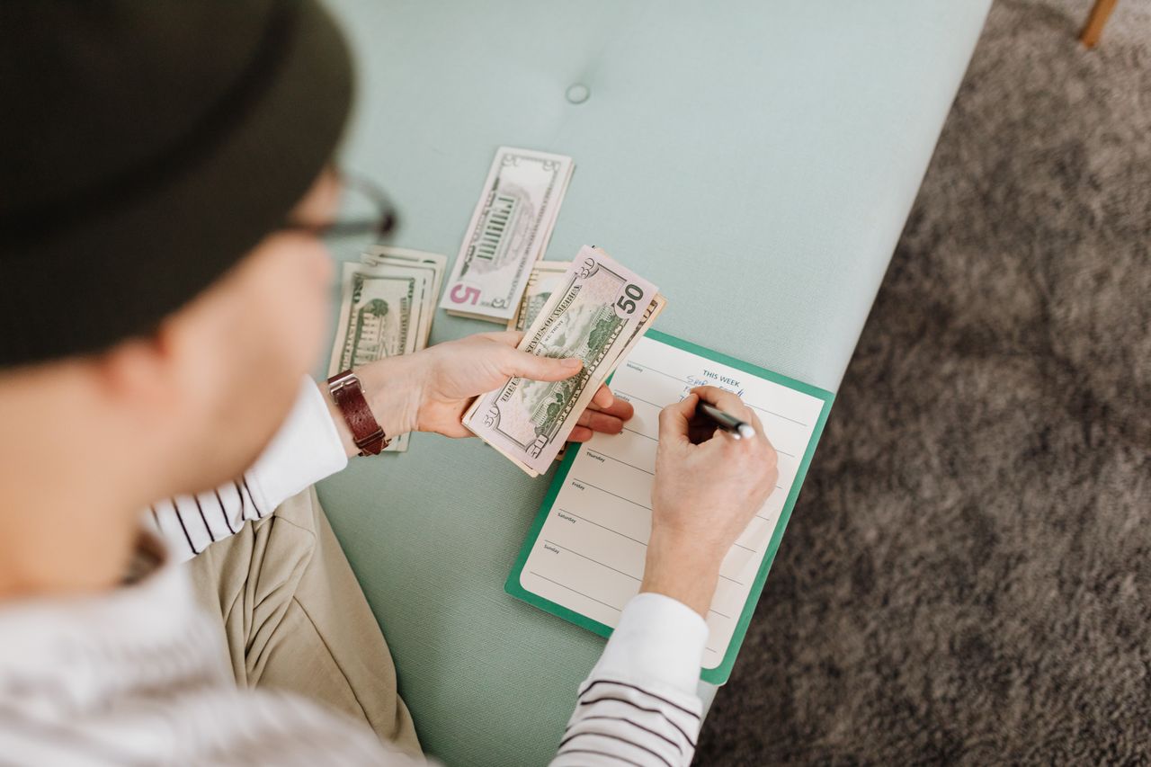 about-01 Individual budgeting with US dollars and a planner, focusing on financial planning.